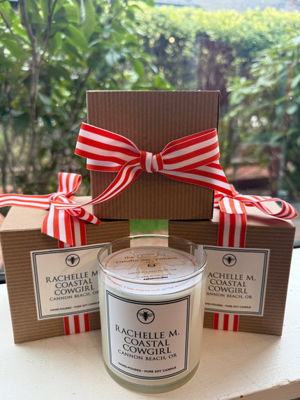 Custom Rachelle M “Coastal Cowgirl” candle with cardboard packaging and ribbon