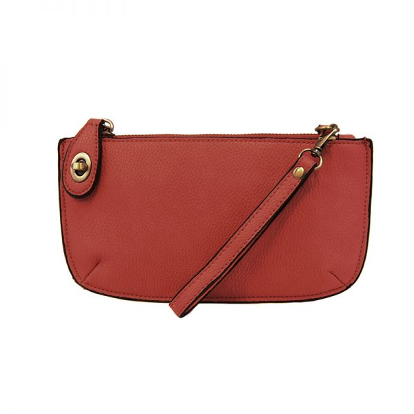 An apple-colored mini crossbody wristlet clutch with brass plated hardware and a printed lining, displayed with the wristlet strap visible