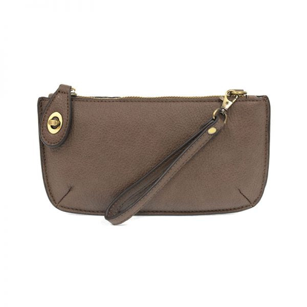 A bark-colored mini crossbody wristlet clutch with brass plated hardware and a printed lining, displayed with the wristlet strap visible