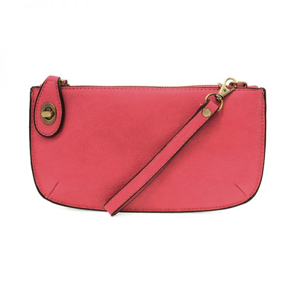 A begonia-colored mini crossbody wristlet clutch with brass plated hardware and a printed lining, displayed with the wristlet strap visible