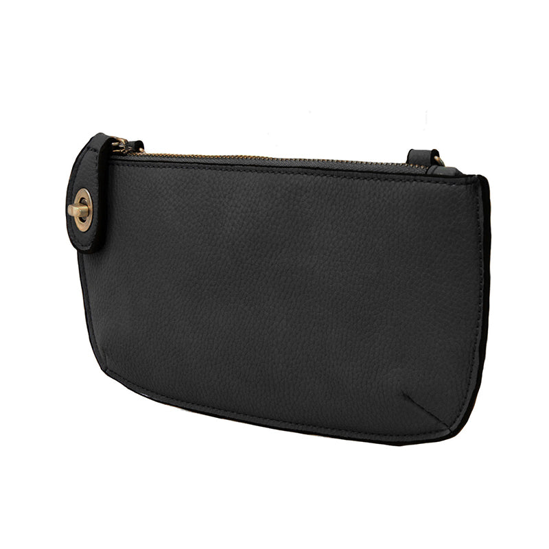 A black-colored mini crossbody wristlet clutch with brass plated hardware and a printed lining, displayed without straps