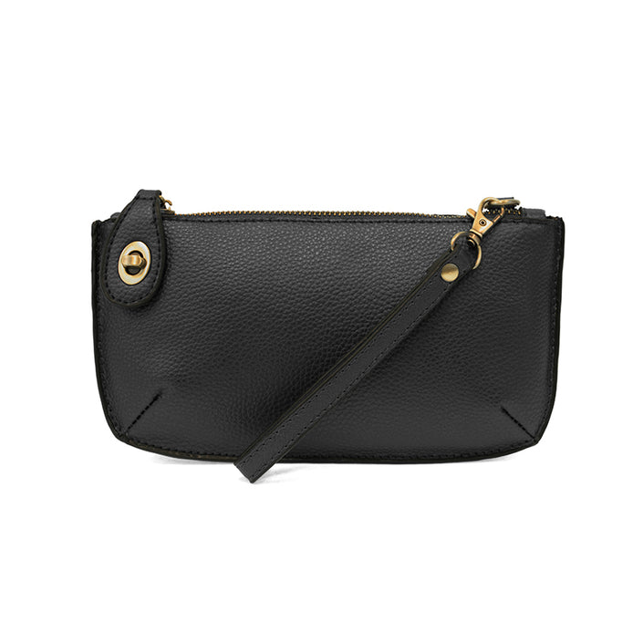 A black-colored mini crossbody wristlet clutch with brass plated hardware and a printed lining, displayed with the wristlet strap visible