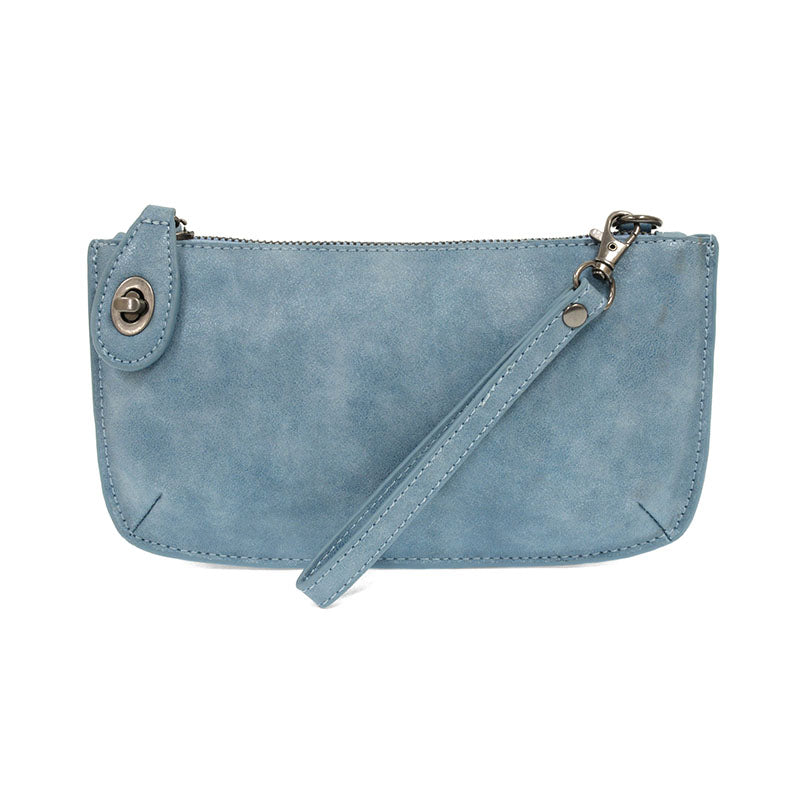 A blue jay-colored mini crossbody wristlet clutch with brass plated hardware and a printed lining, displayed with the wristlet strap visible