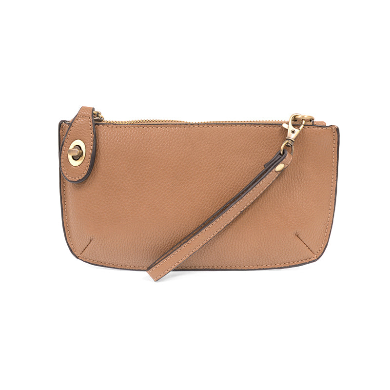 A camel-colored mini crossbody wristlet clutch with brass plated hardware and a printed lining, displayed with the wristlet strap visible