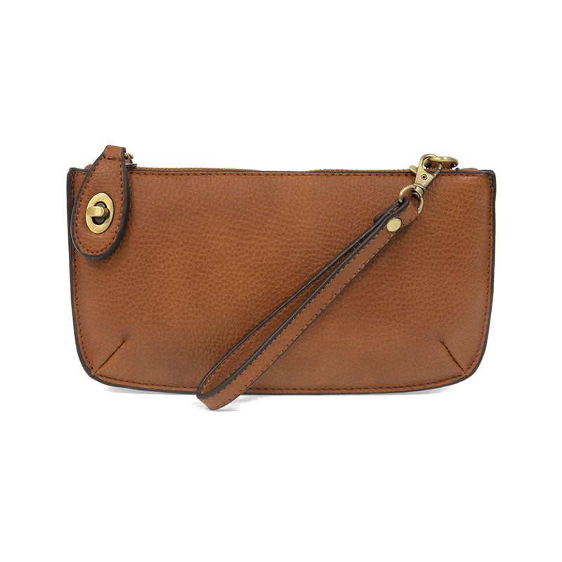 A cedar brown-colored mini crossbody wristlet clutch with brass plated hardware and a printed lining, displayed with the wristlet strap visible