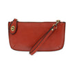 A cherry red-colored mini crossbody wristlet clutch with brass plated hardware and a printed lining, displayed with the wristlet strap visible