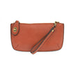 A cinnamon-colored mini crossbody wristlet clutch with brass plated hardware and a printed lining, displayed with the wristlet strap visible