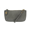 A cloudy sky-colored mini crossbody wristlet clutch with brass plated hardware and a printed lining, displayed with the wristlet strap visible