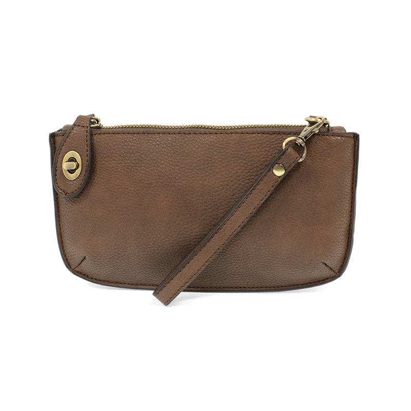 A cocoa-colored mini crossbody wristlet clutch with brass plated hardware and a printed lining, displayed with the wristlet strap visible