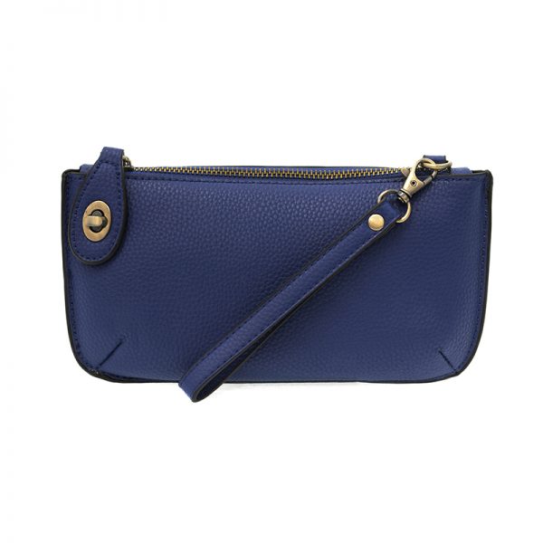 A dark cobalt-colored mini crossbody wristlet clutch with brass plated hardware and a printed lining, displayed with the wristlet strap visible