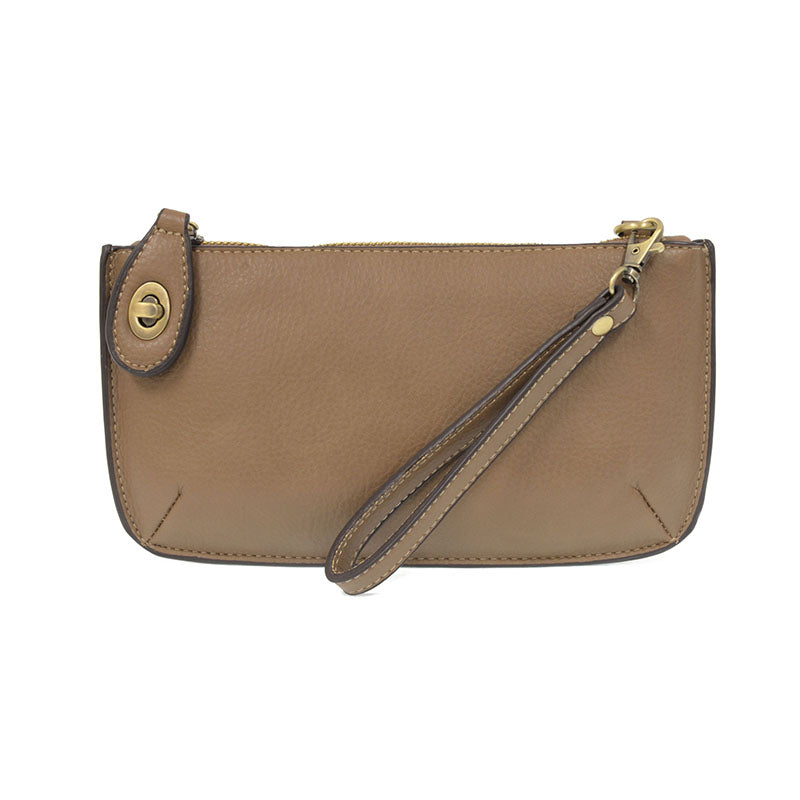 A dark khaki-colored mini crossbody wristlet clutch with brass plated hardware and a printed lining, displayed with the wristlet strap visible