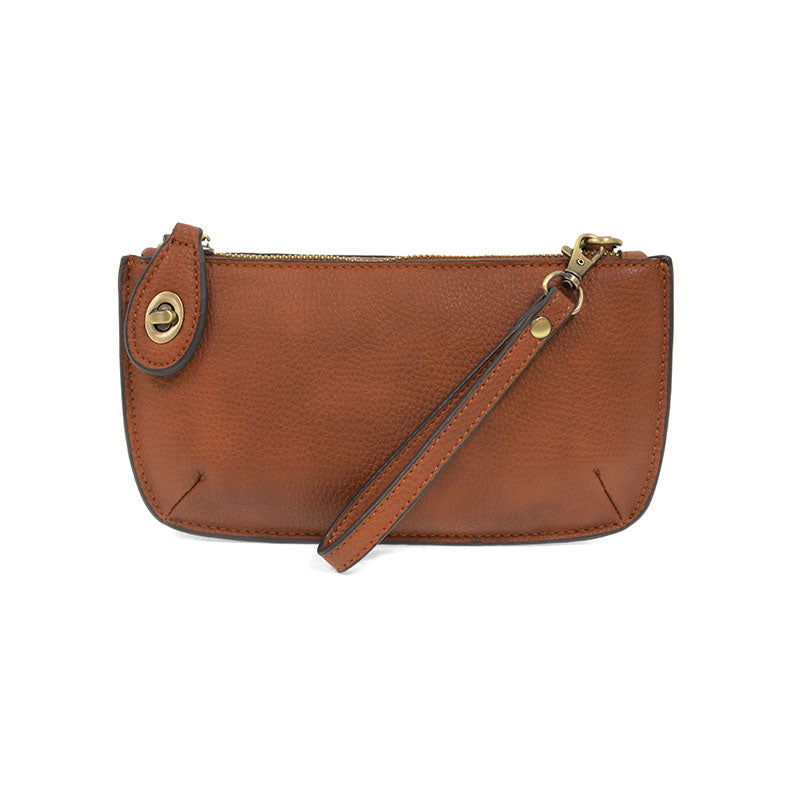 A dark maple-colored mini crossbody wristlet clutch with brass plated hardware and a printed lining, displayed with the wristlet strap visible