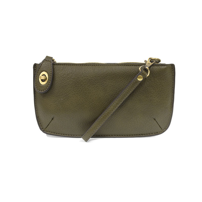 A dark moss-colored mini crossbody wristlet clutch with brass plated hardware and a printed lining, displayed with the wristlet strap visible