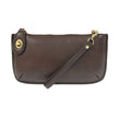 A dark oak-colored mini crossbody wristlet clutch with brass plated hardware and a printed lining, displayed with the wristlet strap visible