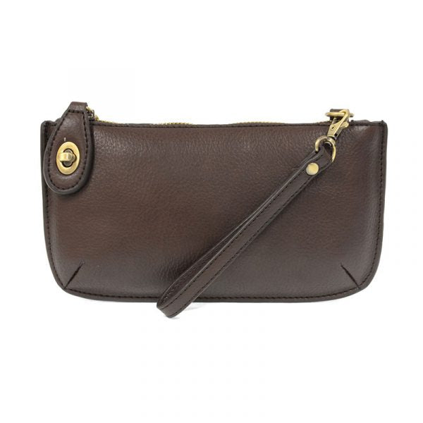 A dark oak-colored mini crossbody wristlet clutch with brass plated hardware and a printed lining, displayed with the wristlet strap visible