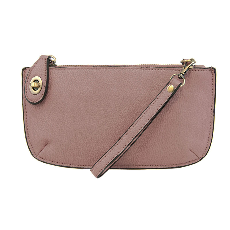 A dusty amethyst-colored mini crossbody wristlet clutch with brass plated hardware and a printed lining, displayed with the wristlet strap visible