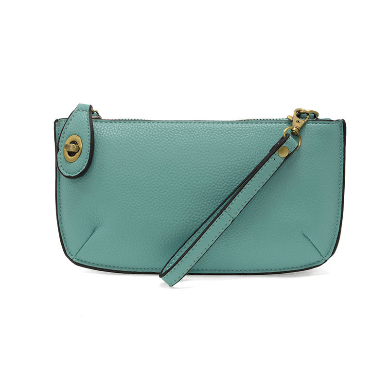 An aqua-colored mini crossbody wristlet clutch with brass plated hardware and a printed lining, displayed with the wristlet strap visible