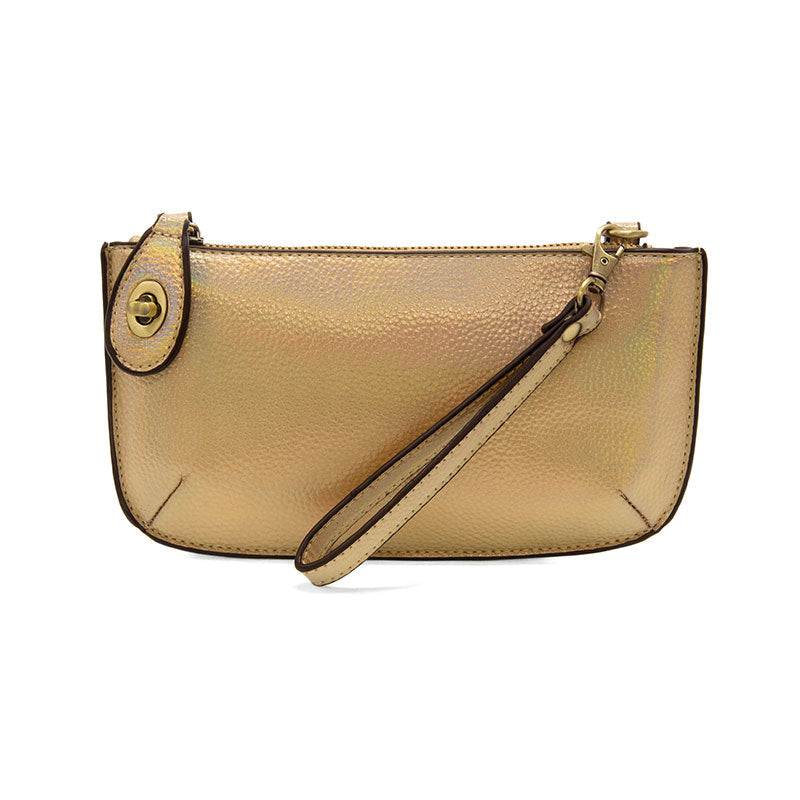 A gold holographic-colored mini crossbody wristlet clutch with brass plated hardware and a printed lining, displayed with the wristlet strap visible