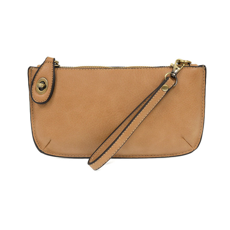A golden oak-colored mini crossbody wristlet clutch with brass plated hardware and a printed lining, displayed with the wristlet strap visible