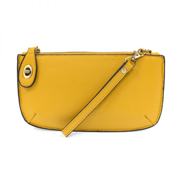 A goldenrod-colored mini crossbody wristlet clutch with brass plated hardware and a printed lining, displayed with the wristlet strap visible