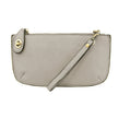 A grey-colored mini crossbody wristlet clutch with brass plated hardware and a printed lining, displayed with the wristlet strap visible