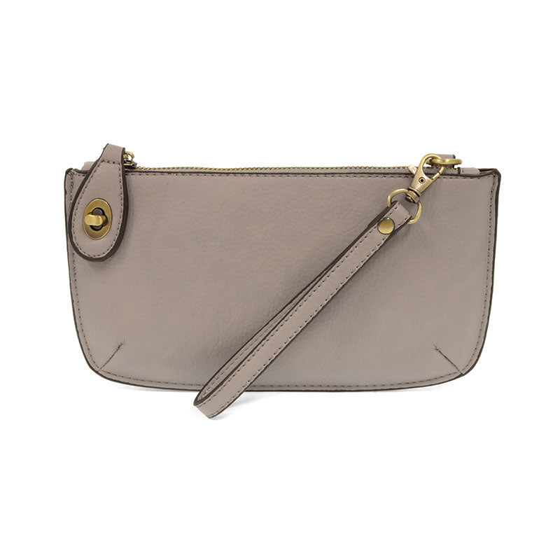 A grey-colored mini crossbody wristlet clutch with brass plated hardware and a printed lining, displayed with the wristlet strap visible