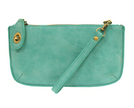 A light turquoise-colored mini crossbody wristlet clutch with brass plated hardware and a printed lining, displayed with the wristlet strap visible