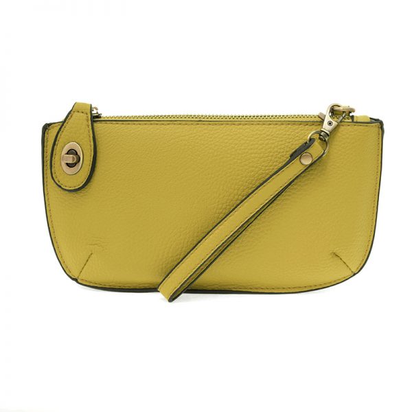 A lime-colored mini crossbody wristlet clutch with brass plated hardware and a printed lining, displayed with the wristlet strap visible