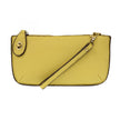 A macaroon-colored mini crossbody wristlet clutch with brass plated hardware and a printed lining, displayed with the wristlet strap visible