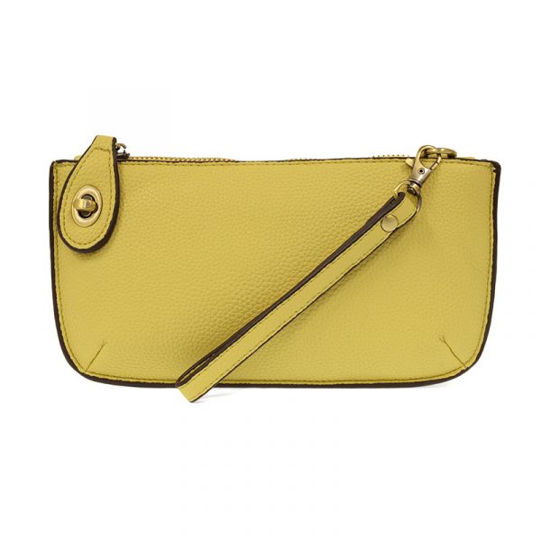 A macaroon-colored mini crossbody wristlet clutch with brass plated hardware and a printed lining, displayed with the wristlet strap visible