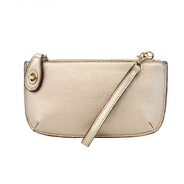 A metallic pearl-colored mini crossbody wristlet clutch with brass plated hardware and a printed lining, displayed with the wristlet strap visible