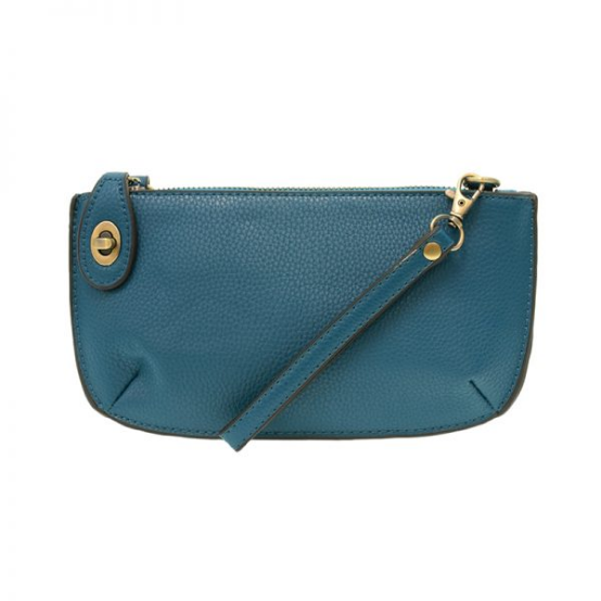 A blue-colored mini crossbody wristlet clutch with brass plated hardware and a printed lining, displayed with the wristlet strap visible