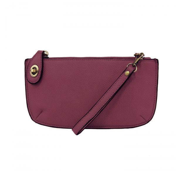 A mulberry-colored mini crossbody wristlet clutch with brass plated hardware and a printed lining, displayed with the wristlet strap visible
