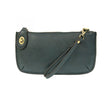 A dark teal-colored mini crossbody wristlet clutch with brass plated hardware and a printed lining, displayed with the wristlet strap visible