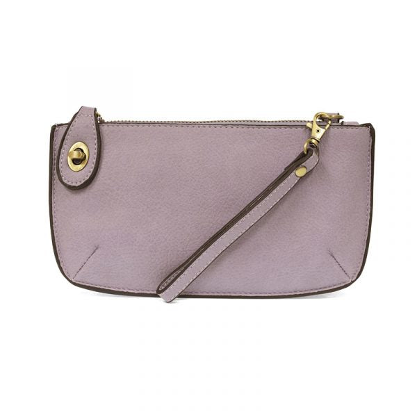 A wisteria-colored mini crossbody wristlet clutch with brass plated hardware and a printed lining, displayed with the wristlet strap visible