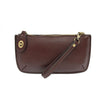 An oxblood-colored mini crossbody wristlet clutch with brass plated hardware and a printed lining, displayed with the wristlet strap visible