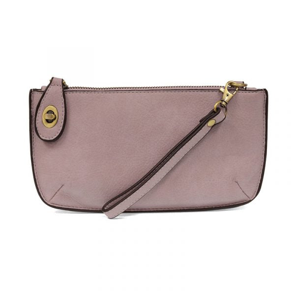 A petunia purple-colored mini crossbody wristlet clutch with brass plated hardware and a printed lining, displayed with the wristlet strap visible