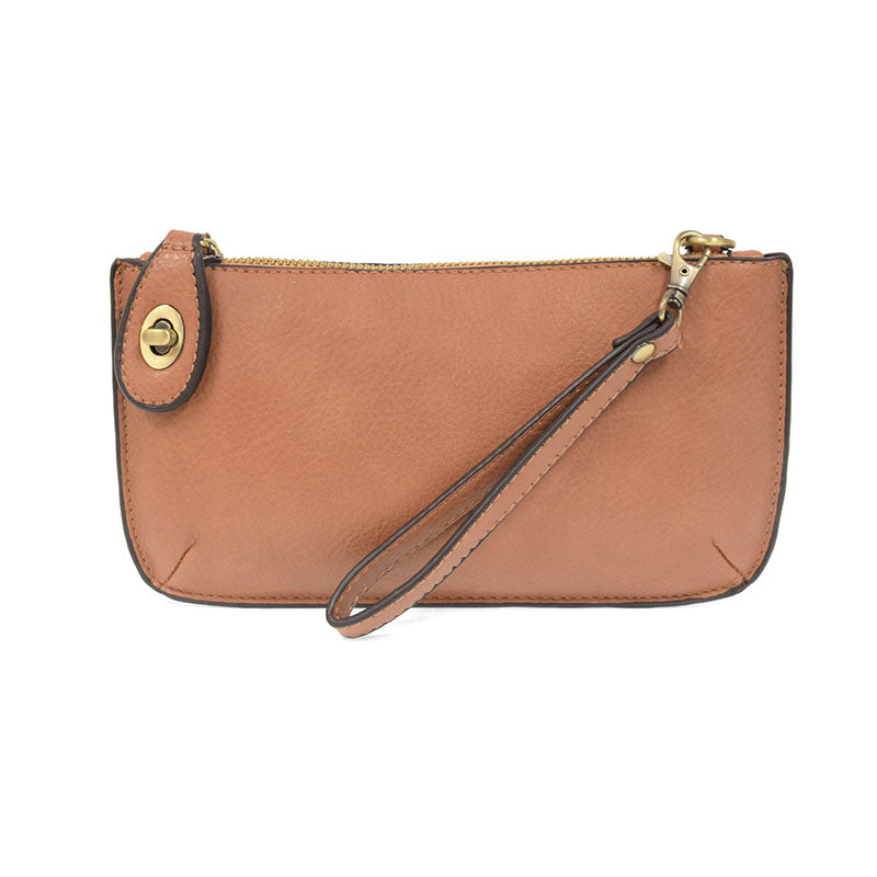 A rosewood-colored mini crossbody wristlet clutch with brass plated hardware and a printed lining, displayed with the wristlet strap visible