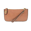 A rosewood-colored mini crossbody wristlet clutch with brass plated hardware and a printed lining, displayed with the wristlet strap visible
