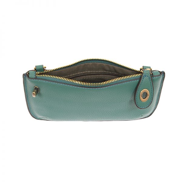 A ultramarine-colored mini crossbody wristlet clutch with brass plated hardware and a printed lining, internal view