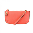 A watermelon-colored mini crossbody wristlet clutch with brass plated hardware and a printed lining, displayed with the wristlet strap visible