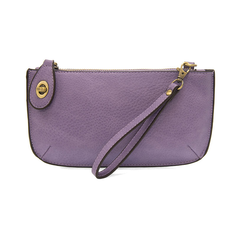 A wild orchid-colored mini crossbody wristlet clutch with brass plated hardware and a printed lining, displayed with the wristlet strap visible