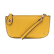 A yellow-colored mini crossbody wristlet clutch with brass plated hardware and a printed lining, displayed with the wristlet strap visible