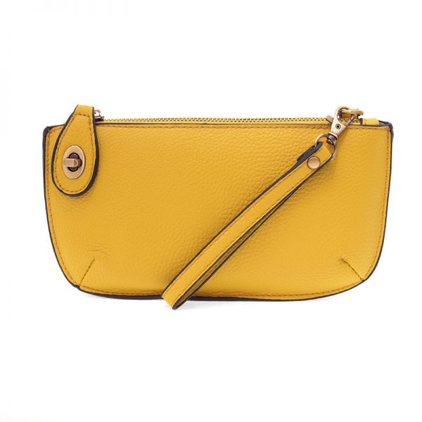 A yellow-colored mini crossbody wristlet clutch with brass plated hardware and a printed lining, displayed with the wristlet strap visible