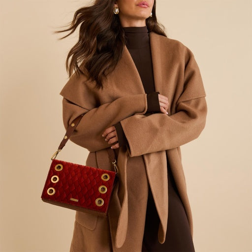 Woman wearing a brown coat holding a bag 