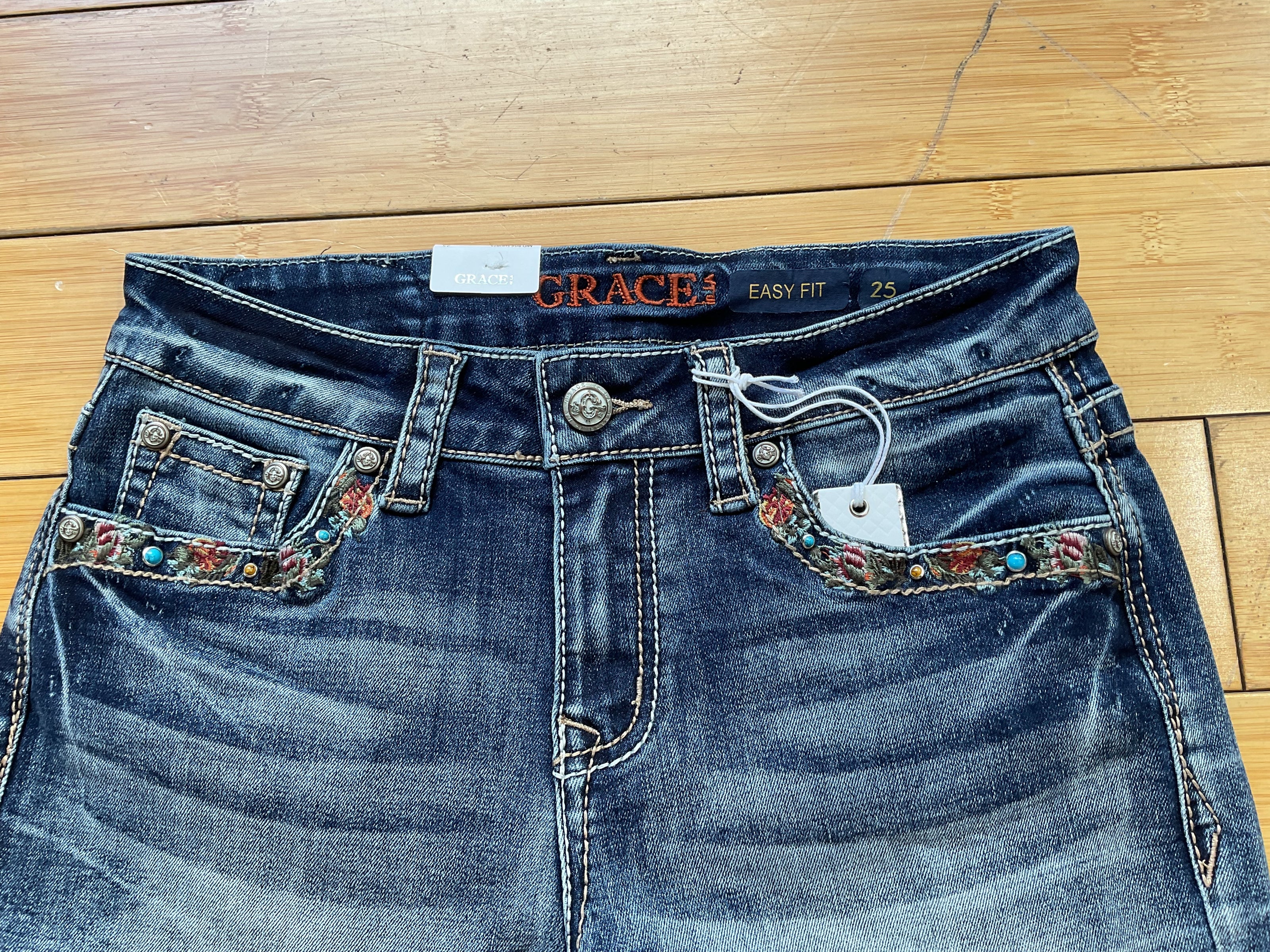 Grace denim stud and butterfly embroidered short-front pocket detail