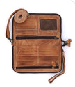 The Bed|Stu Templeton II Clutch Wallet, crafted from brown vegetable-tanned leather, is shown unzipped with card slots, two zippered compartments, a mesh ID slot, and wrist and shoulder straps on a white background.
