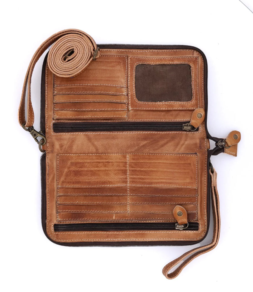 The Bed|Stu Templeton II Clutch Wallet, crafted from brown vegetable-tanned leather, is shown unzipped with card slots, two zippered compartments, a mesh ID slot, and wrist and shoulder straps on a white background.